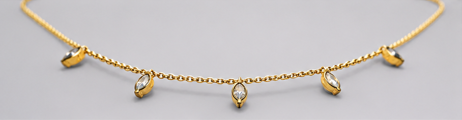 Low-angle view of SEELE gold-tone necklace with five dangling clear crystal charms on a fine chain.